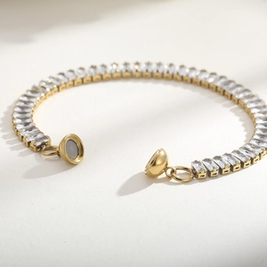 Detail shot of golden baguette-cut zircon tennis bracelet with magnetic clasp closure