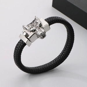 Detailed view of punk wolf head charm on black braided leather bracelet for men