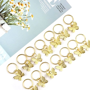 Flat lay of 14 gold butterfly hair charms for DIY braids on an aesthetic background
