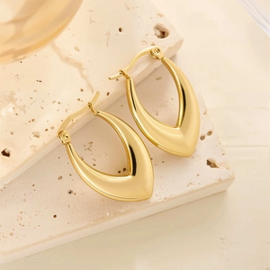 Vue détaillée des boucles d'oreilles goutte en acier titane plaqué or 18k sur pierre