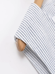 Détail du tissu à rayures bleues et blanches avec fils pailletés argentés et maille fine