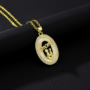 Detailed view of gold necklace with mother-child silhouette and shell inlay