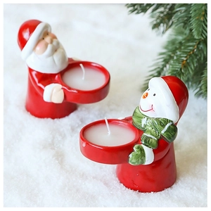 Detail of Santa and Snowman ceramic candle holders on snow background for Christmas