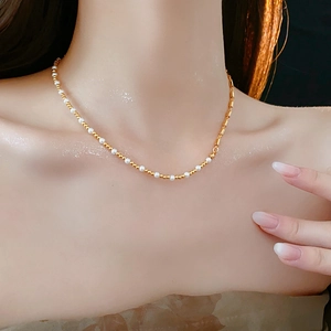 Detail of round pearls and gold beads necklace on neck, modern elegant jewelry