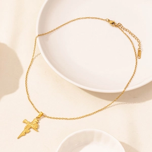 Cross and rose pendant necklace in 18K gold-plated stainless steel on ceramic plate