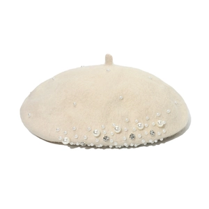 Close-up of beige wool beret featuring elegant pearl and rhinestone embellishments