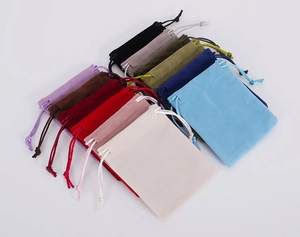 Colorful velvet drawstring jewelry pouches displayed in a fan arrangement on white back