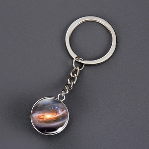 Detailed macro view of silver solar system keychain with spiral nebula galaxy pendant