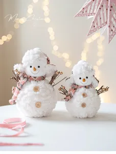 Close-up of two plush Christmas snowmen with pink checkered scarves and wooden buttons