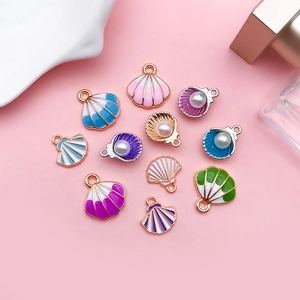Detailed macro view of colorful enamel shell charms with pearls and golden borders
