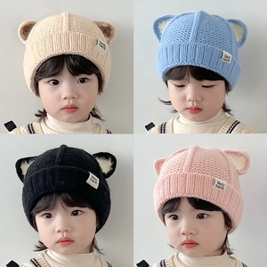 Winter knitted baby hat with cute cat ears in beige, blue, black and pink colors