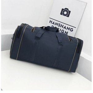 Detail of navy blue nylon travel bag with golden zippers and beige piping accents