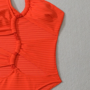 Détail d'un maillot de bain corail côtelé avec des motifs ajourés tissés complexes