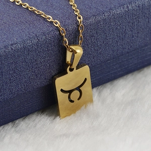 Gros plan du collier pendentif Taureau plaqué or 18 carats sur une boîte à bijoux bleue