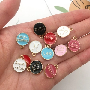 Colorful zodiac enamel charms in KC gold with various constellation names on hand