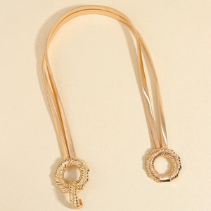 Detail of gold metal spring waist chain with geometric round textured buckle for dresses