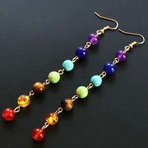 Detail of colorful chakra natural stone beads on gold-plated long dangle drop earrings
