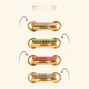 Detailed view of stacked zircon rings in gold finish with white, green, pink, and blue gems