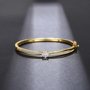 Macro shot of gold-plated crossover bangle with large round zircon and pavé setting