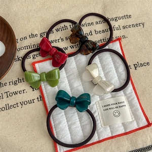 Set of 5 acetate bow hair ties in assorted colors including red, green and white