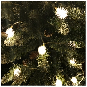 Close-up of warm white LED snowball string lights on a Christmas tree with pine cones