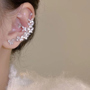 Close-up of elegant silver zircon butterfly ear cuff and stud earring set on a model