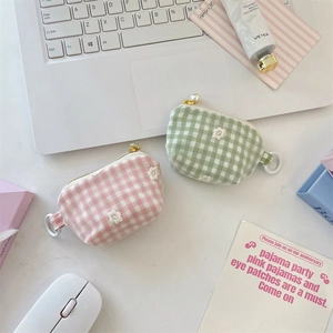 Close-up of plaid fabric coin purses with 3D floral embroidery and pearl zipper details