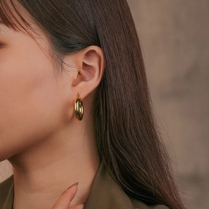 Elegant gold-plated 925 sterling silver hoop earrings worn by a model in a side view