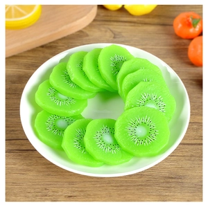 Vue détaillée de dix tranches de kiwi réalistes en PVC sur une assiette décorative blanche