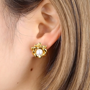 Detaillierte Nahaufnahme eines goldenen Blumenohrrings mit Perle an einem Modell