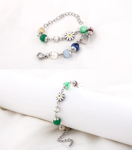 Detailed macro view of multi-color beads, daisy charms and dice on stainless steel bracelet