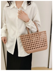 Pink woven hollow jelly handbag shown on model for summer beach or casual vacation use