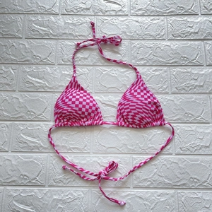 Flachbildaufnahme eines rosa karierten Bikini-Oberteils mit verstellbaren Trägern am Rücken