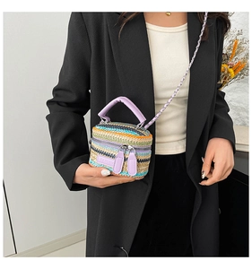 Dettaglio macro delle strisce di rafia multicolore e targhetta fashion sulla mini borsa