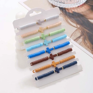 Close-up of bohemian 8-piece clay bead bracelet set with matching cross pendants