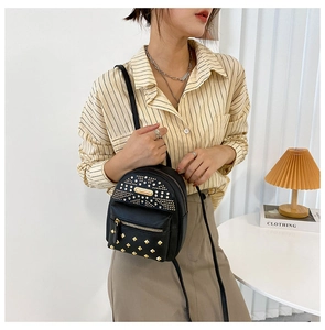 Close-up of a black PU leather mini backpack featuring golden studs and zippers