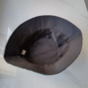 Dettaglio interno del cappello mimetico con cuciture rinforzate ed etichetta lavaggio