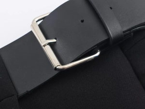 Gros plan d'une ceinture en cuir noir avec une boucle en métal argenté poli