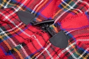 Close-up of a classic red tartan cape featuring a black faux-leather toggle button closure