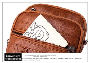 Detail of a brown textured leather crossbody bag showing a functional front pocket for cards