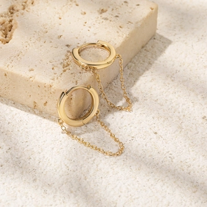 Detail of S925 sterling silver gold plated hoop earring with minimalist hanging chain