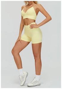 Detail of yellow seamless yoga set featuring double-strap sports bra and high-waisted shorts