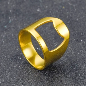 Detailed view of a gold stainless steel bottle opener ring on a dark textured surface