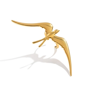 Artistic detail of gold swallow ring with a bird-shaped shadow on white background