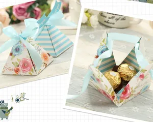 Detail of pyramid paper gift boxes with blue stripes and floral patterns for wedding favors