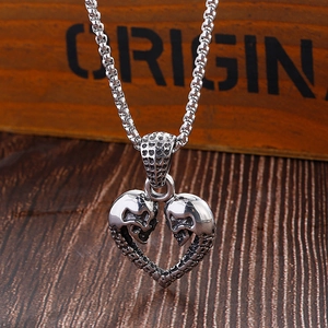Détail du collier en acier titane argenté avec pendentif cœur double crâne sur chaîne
