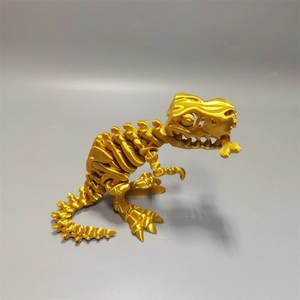 Macro detail of a gold 3D printed T-Rex skeleton model biting a bone on grey background