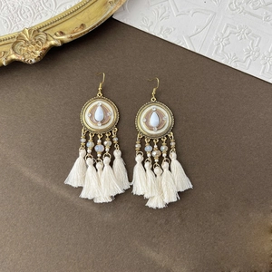 Bohemian gold-tone drop earrings with white crystal stones and fringe feathers