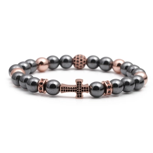 Cross beaded bracelet with tiger eye beads and rose gold zircon accents on white background