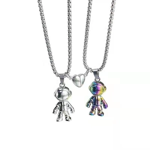 Magnetic astronaut couple necklaces in silver and rainbow finish with heart pendant